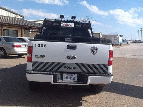 A white ford police truck is parked in a parking lot
