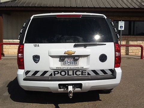 A white police suv is parked in a parking lot
