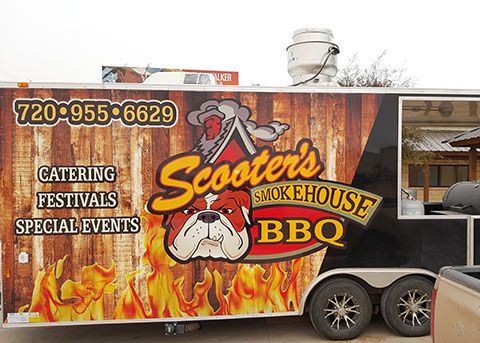 A scooter 's smokehouse bbq trailer is parked on the side of the road.