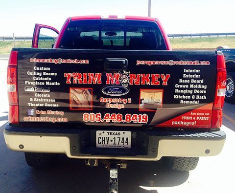 A red truck with a sticker on the back that says trim monkey