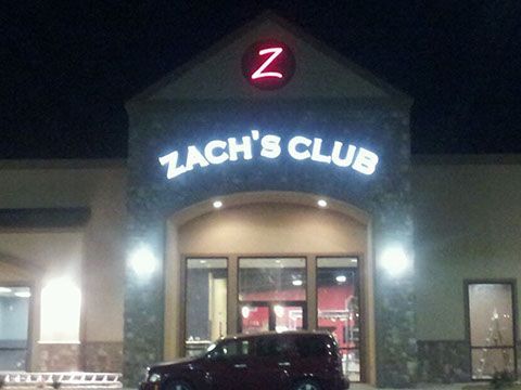 A car is parked in front of zach 's club