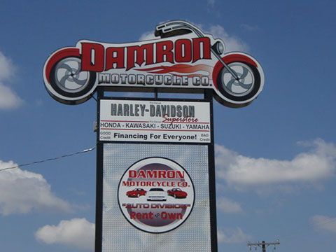 A sign for damron motorcycle co. has a harley davidson logo on it