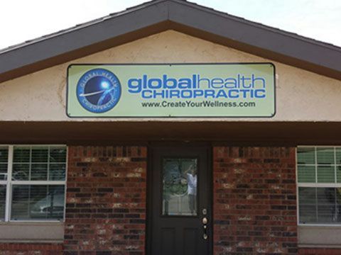 A brick building with a sign that says global health chiropractic