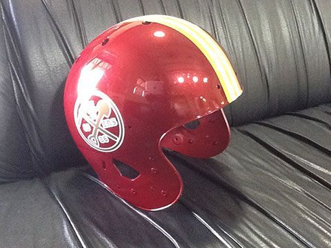 A red helmet is sitting on a black leather couch