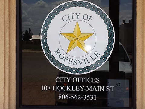 A city of ropesville logo is on a window