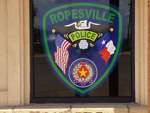 Ropesville police emblem on a glass window