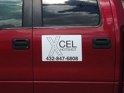 A red truck with a xcel hotshot sign on the door