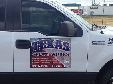 A white truck with a sign on the side that says texas steam works