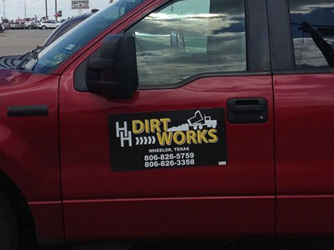 A red truck with a sign that says h dirt works