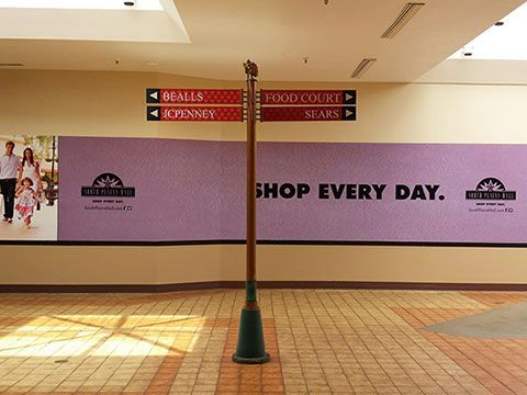 A sign in a mall that says shop every day