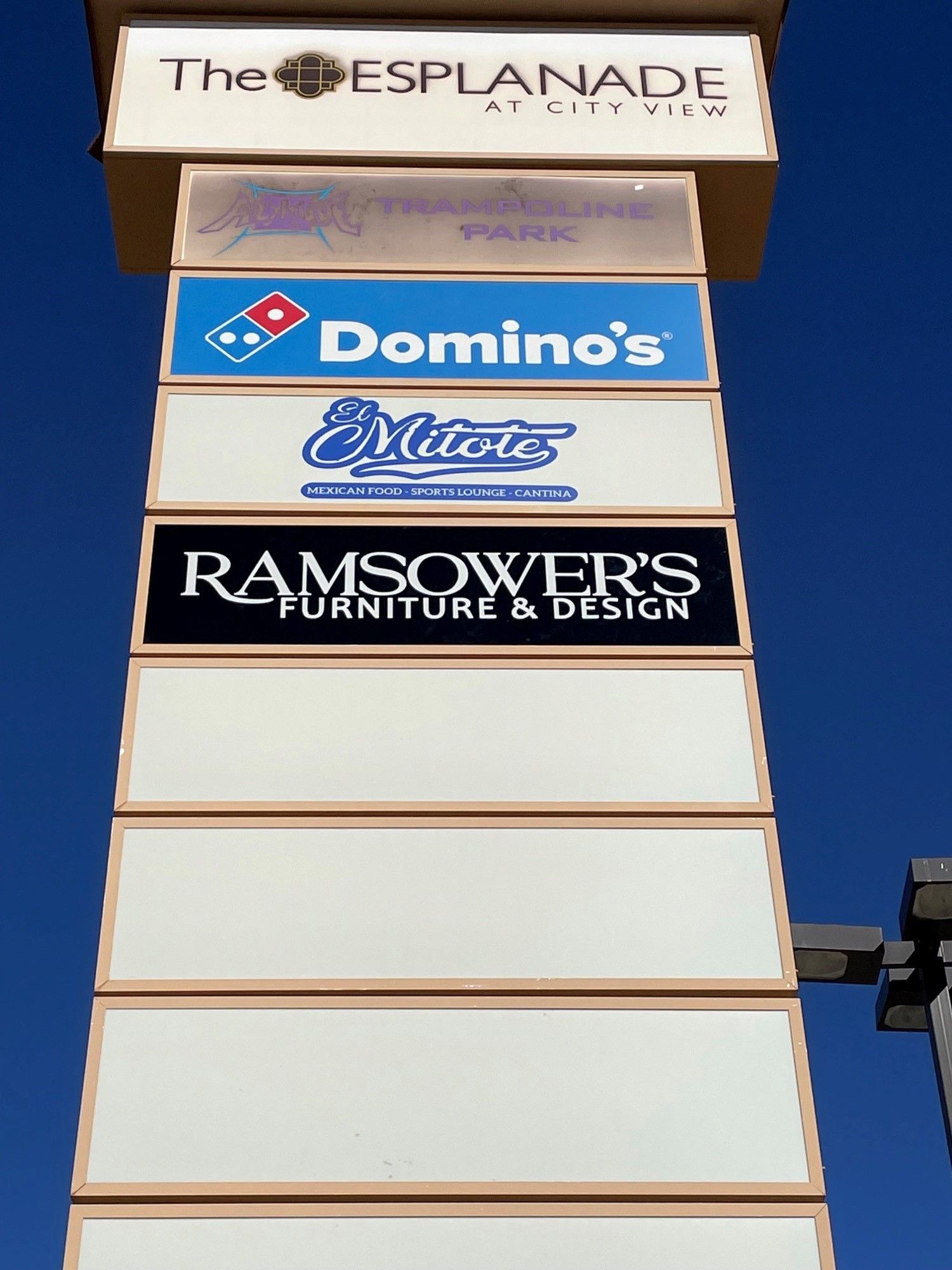 A tall building with domino 's and ramsower 's furniture and design on it