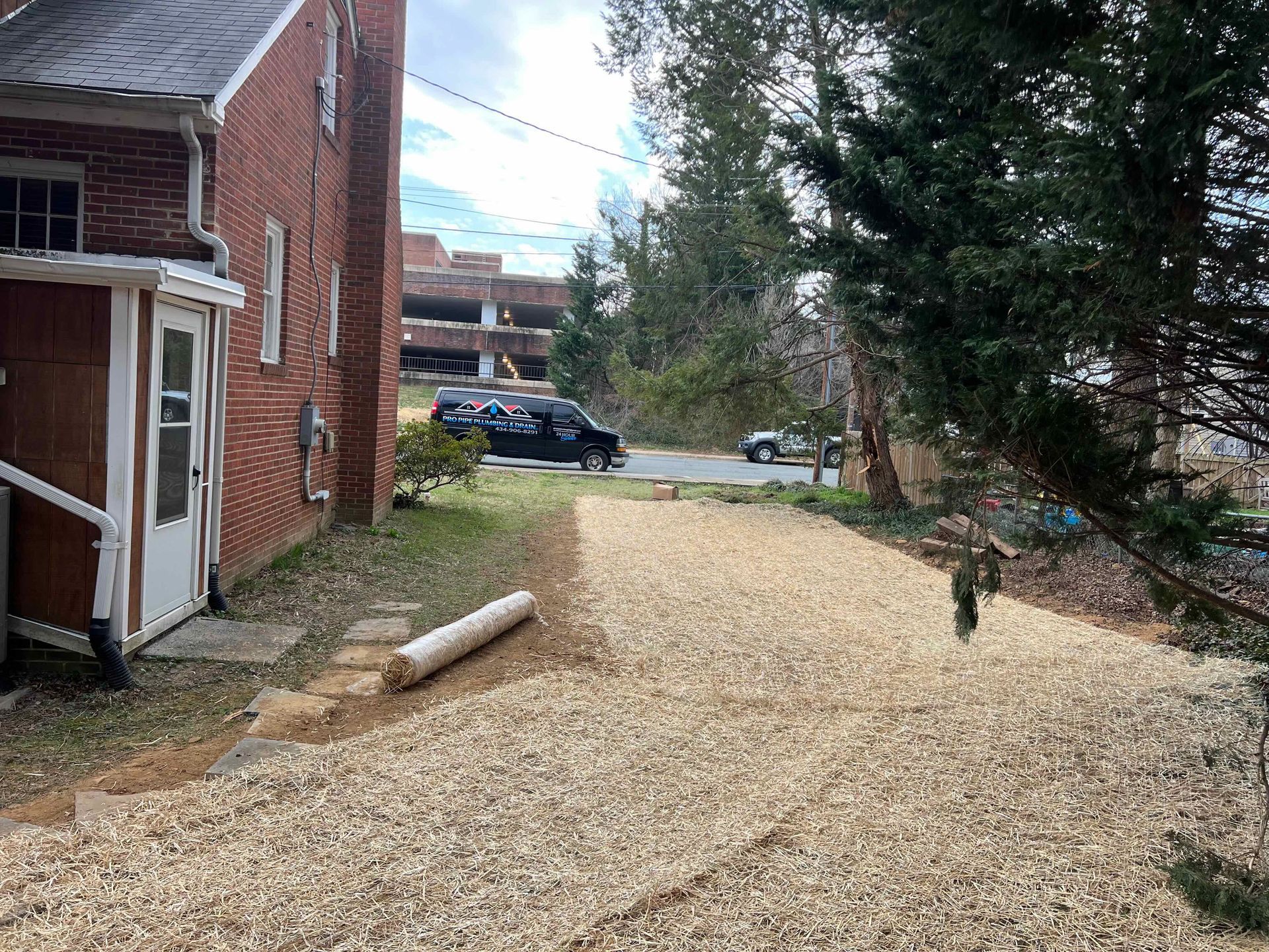 A gravel driveway is being built in front of a brick building.