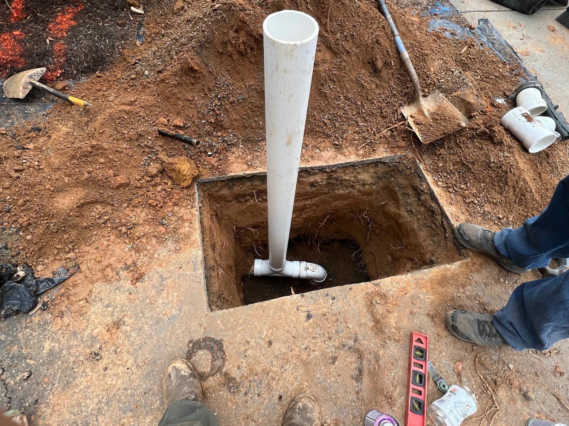 A pipe is being installed in a hole in the ground.