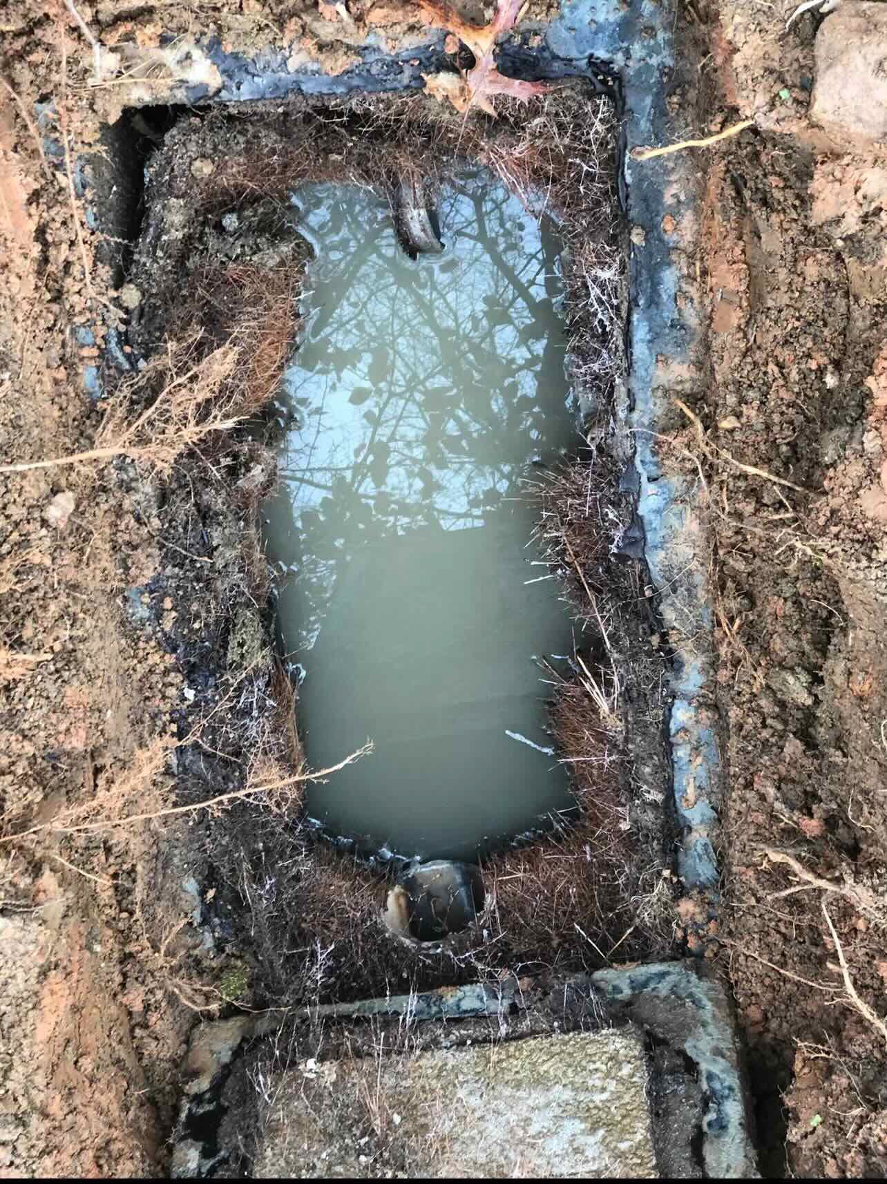 A hole in the ground with water coming out of it.