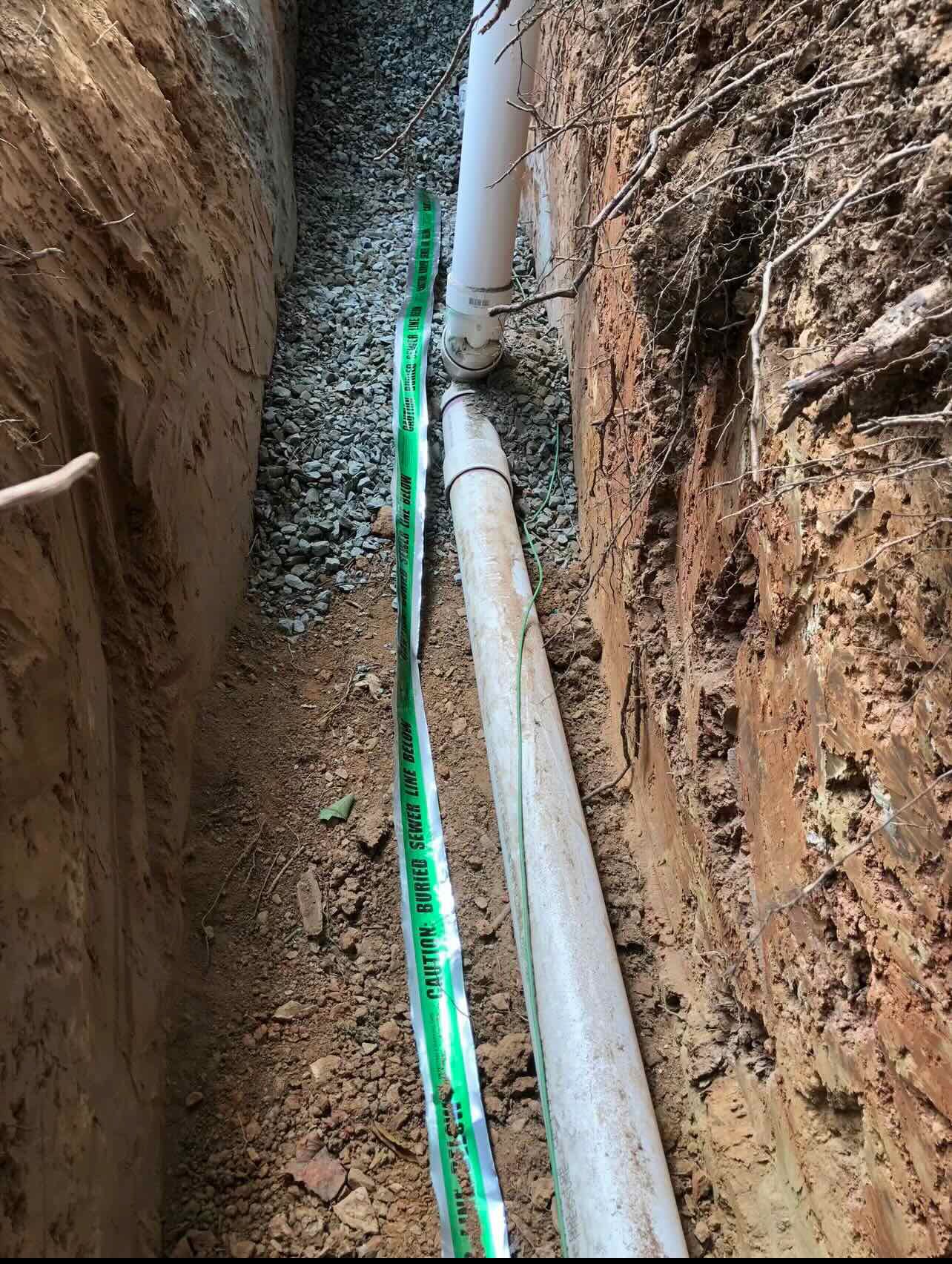 A pipe is being installed in a trench.