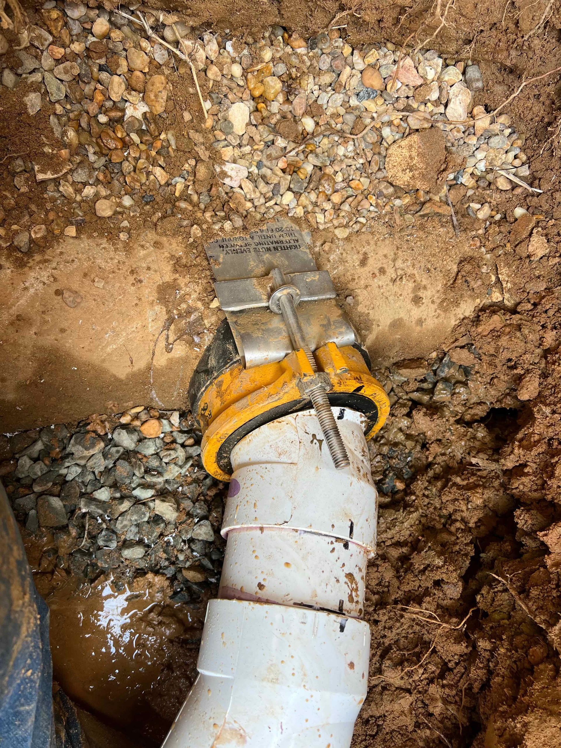 A close up of a drain pipe in the dirt.