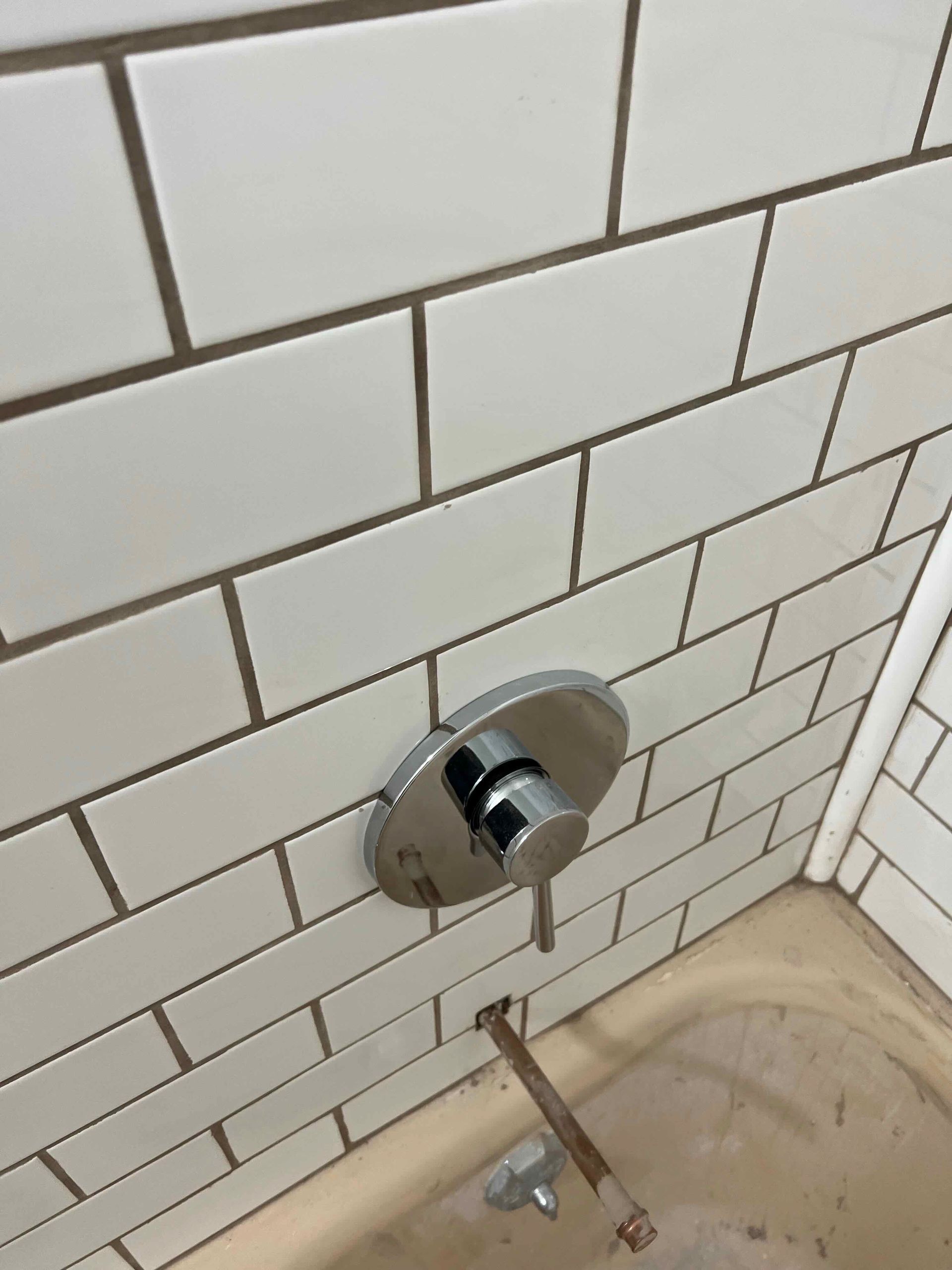A bathroom with white subway tiles and a bathtub