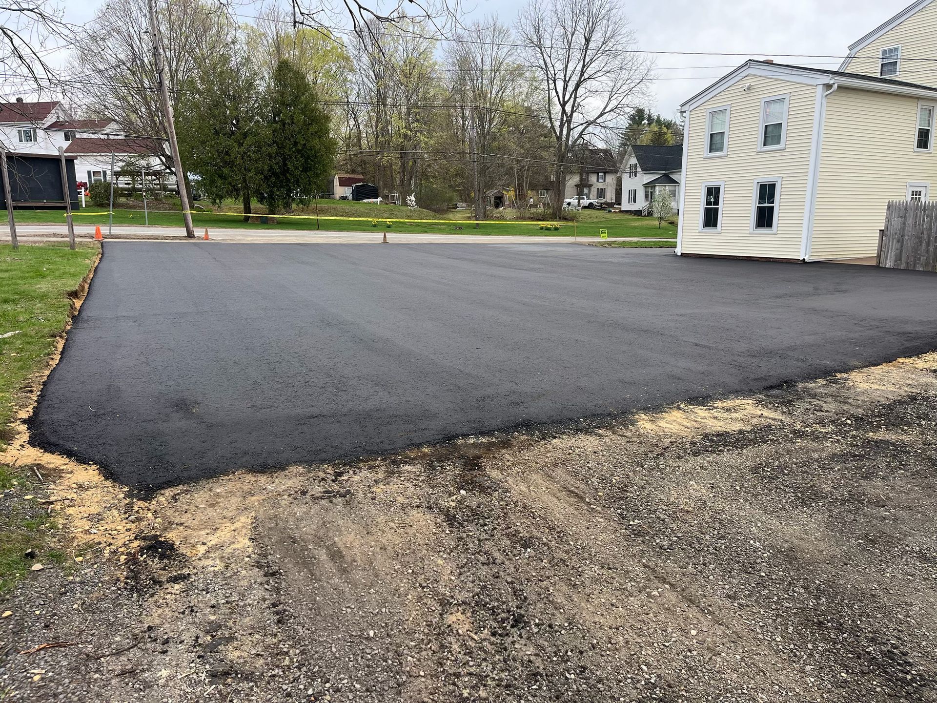 A newly paved driveway with a house in the background.