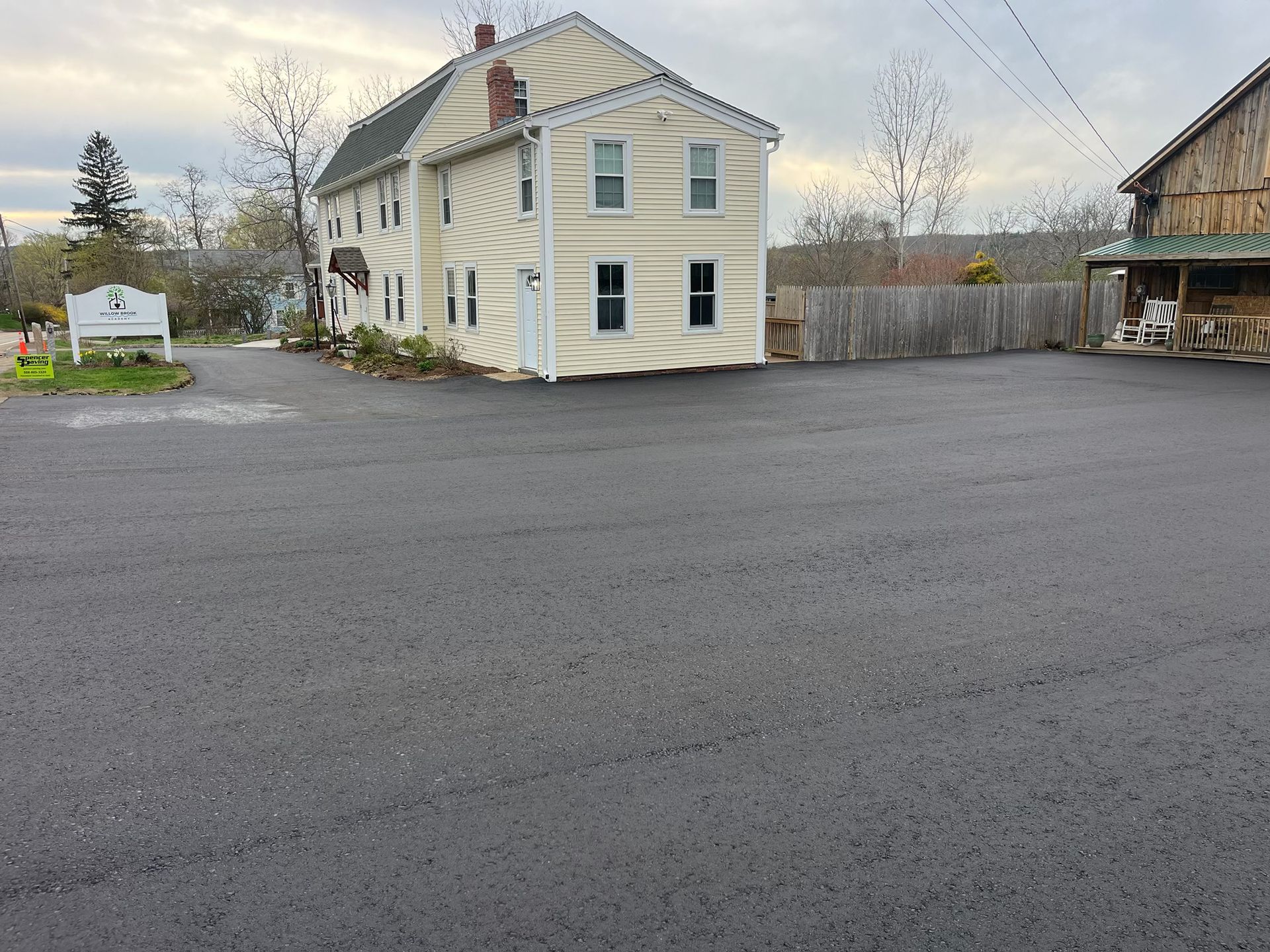 A large white house sits in the middle of a parking lot