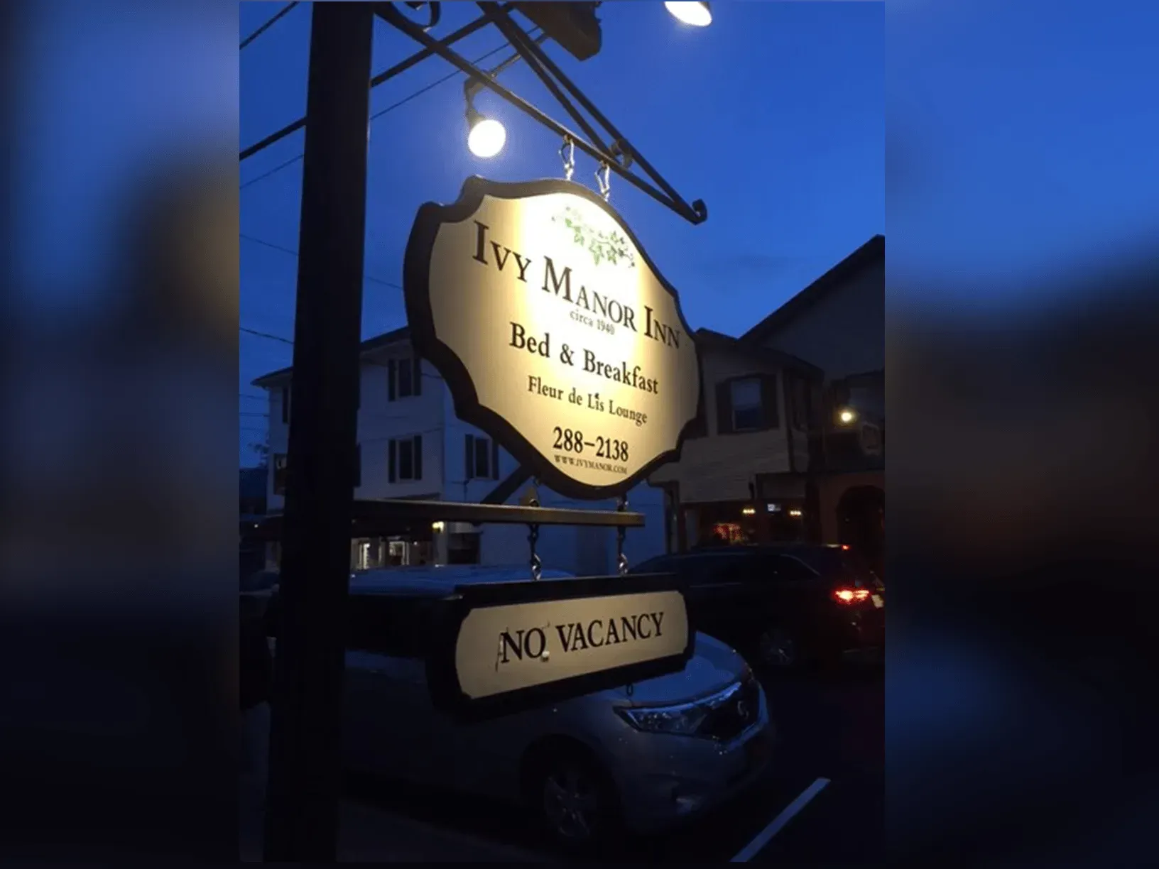 Sign for Ivy Manor Inn, a Bed & Breakfast, illuminated at dusk,