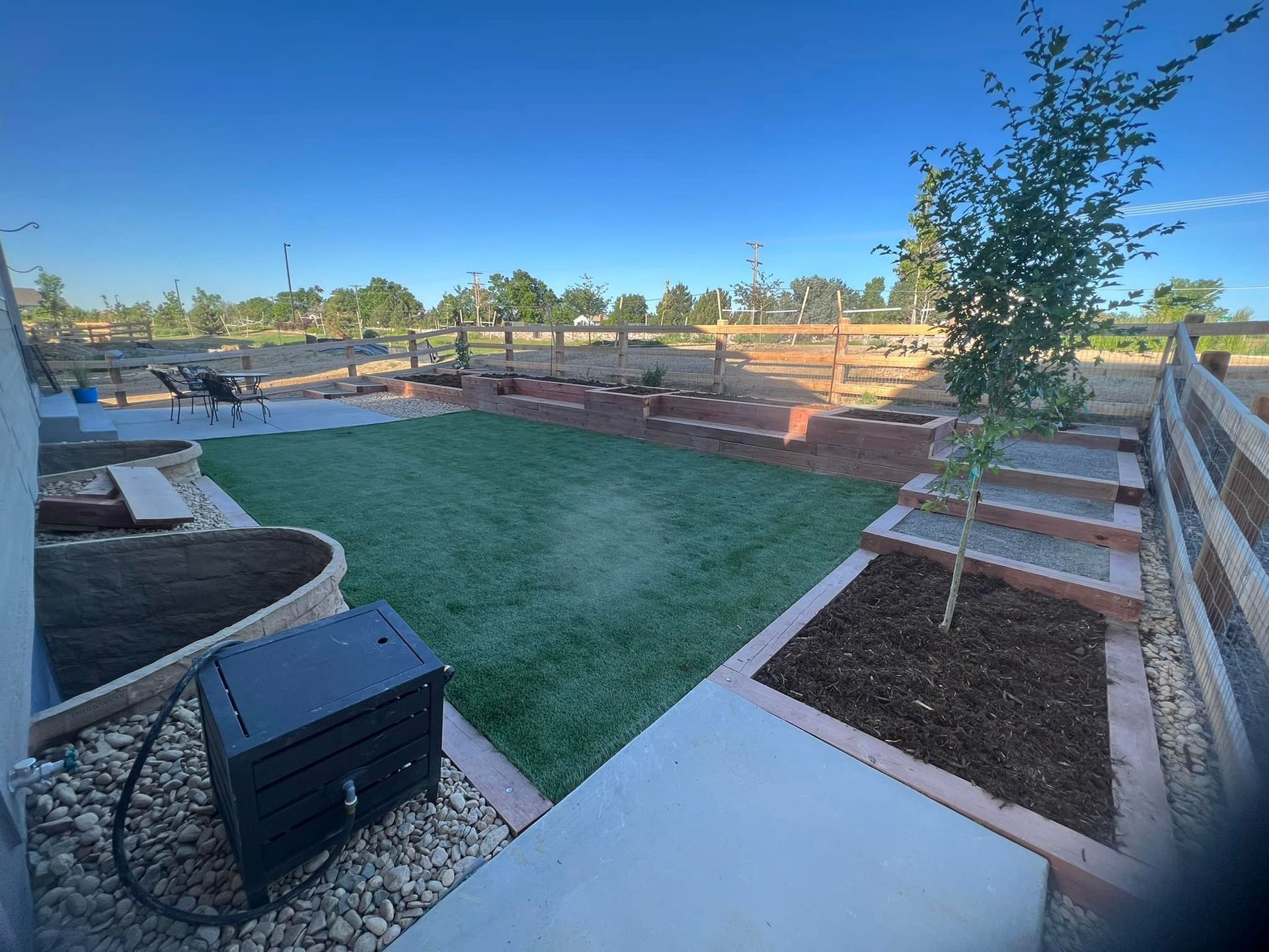 Artistic Escapes  stepped terraces of wood garden raised bed planter boxes, creating a frame for the organic art created through plants adding dimension in height adds character to this outdoor living space EATON COLORADO landscape design landscape installation garden bed raised garden every angle adds interest and functionality