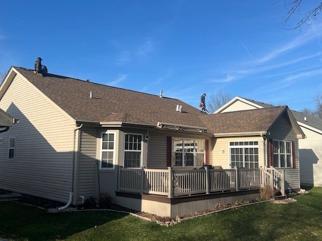 The back of a house with a deck and a roof.
