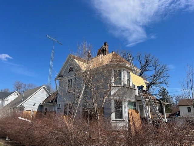A man is working on the roof of a house.