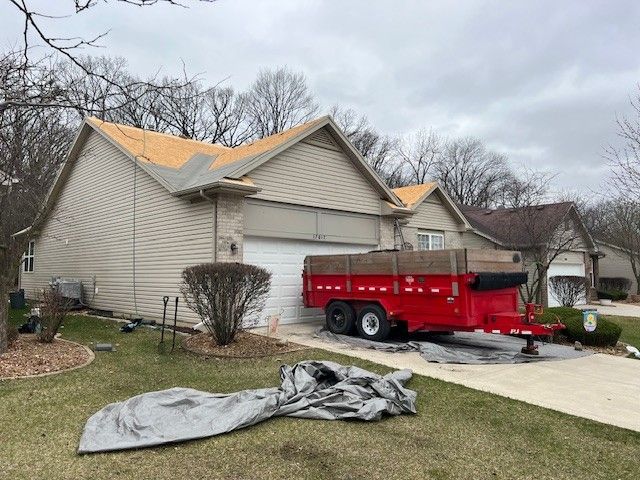 A house with a red trailer parked in front of it.