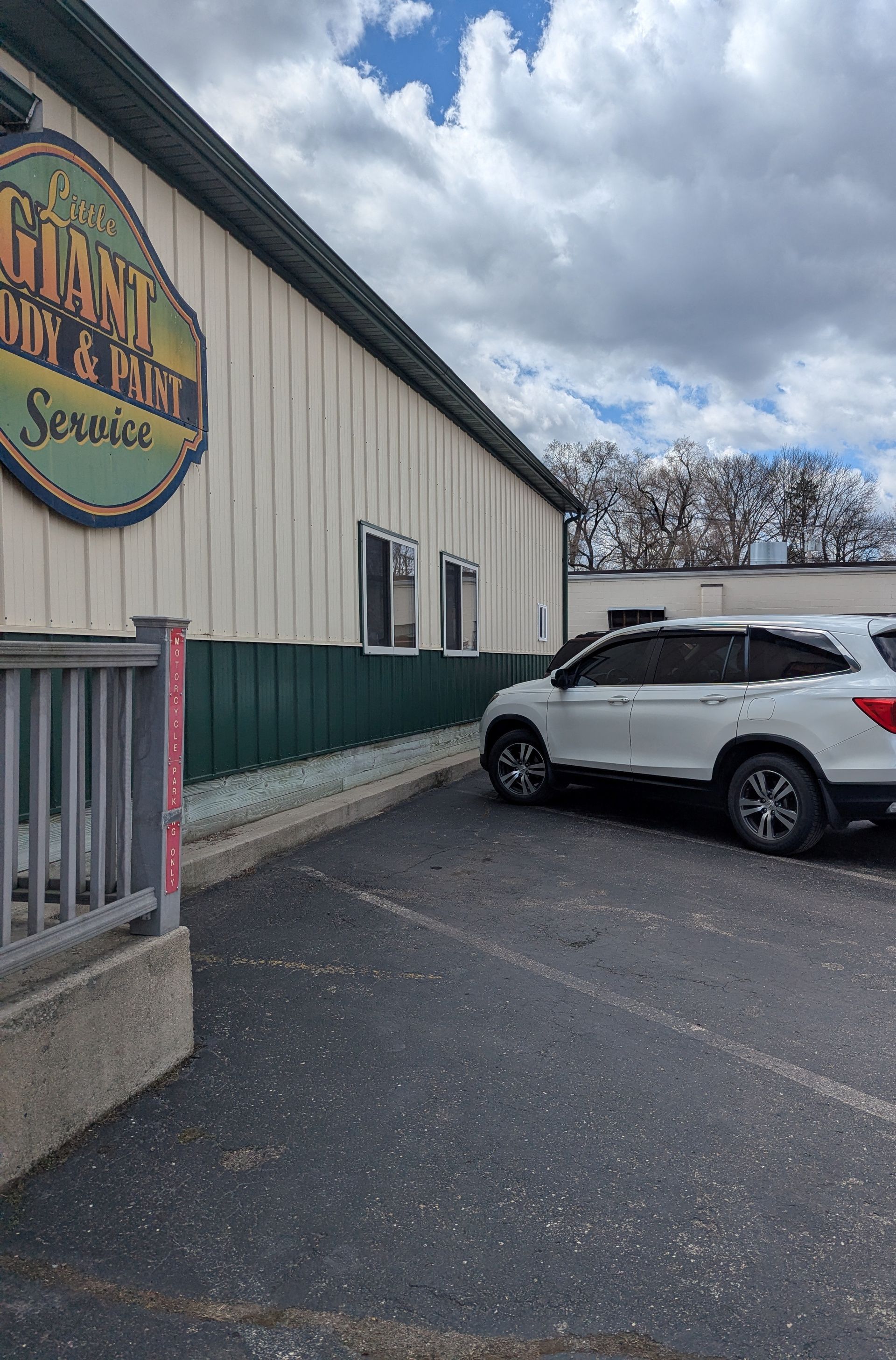 A white car is parked in front of a building