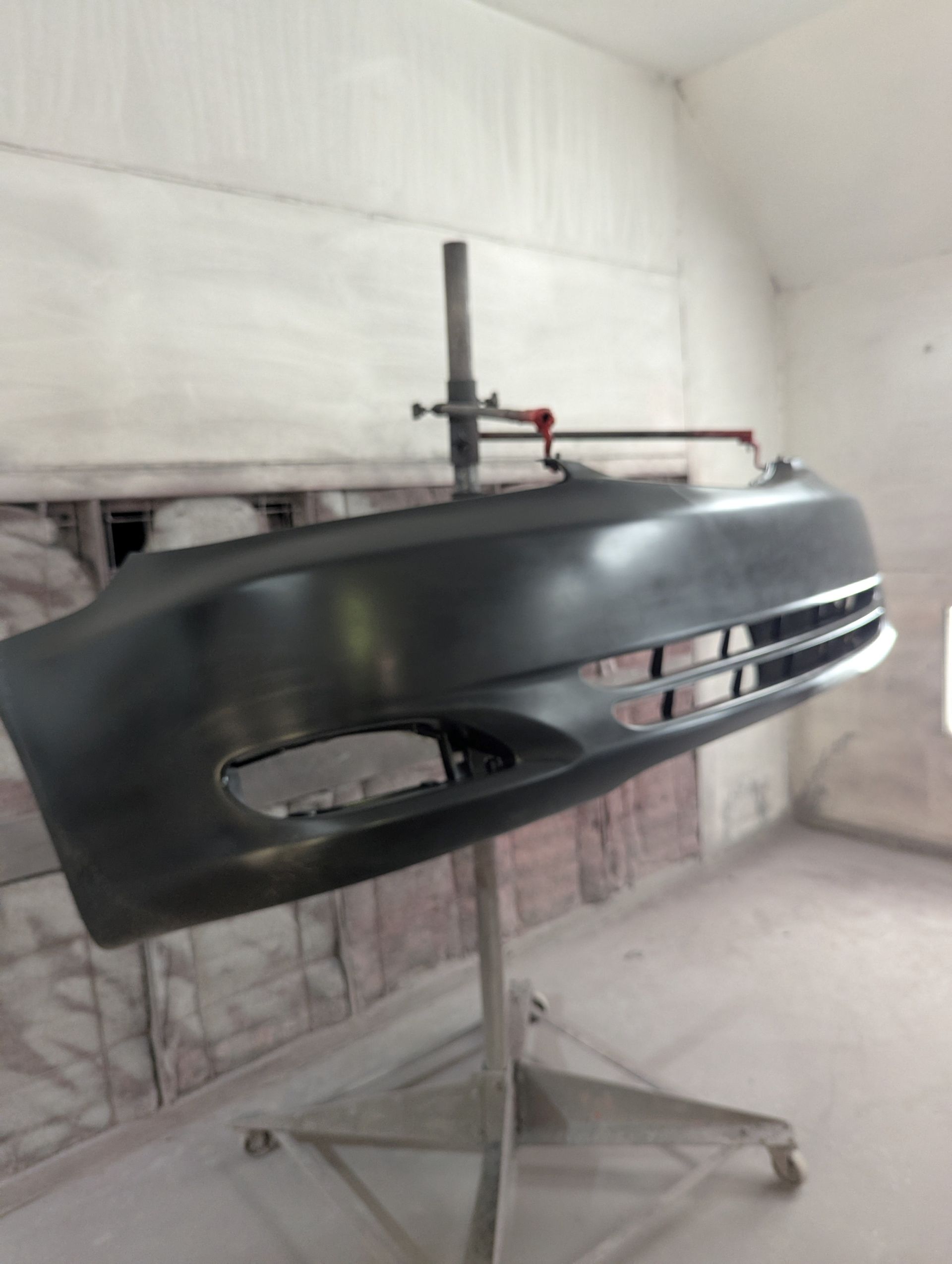 A car bumper is sitting on a stand in a room