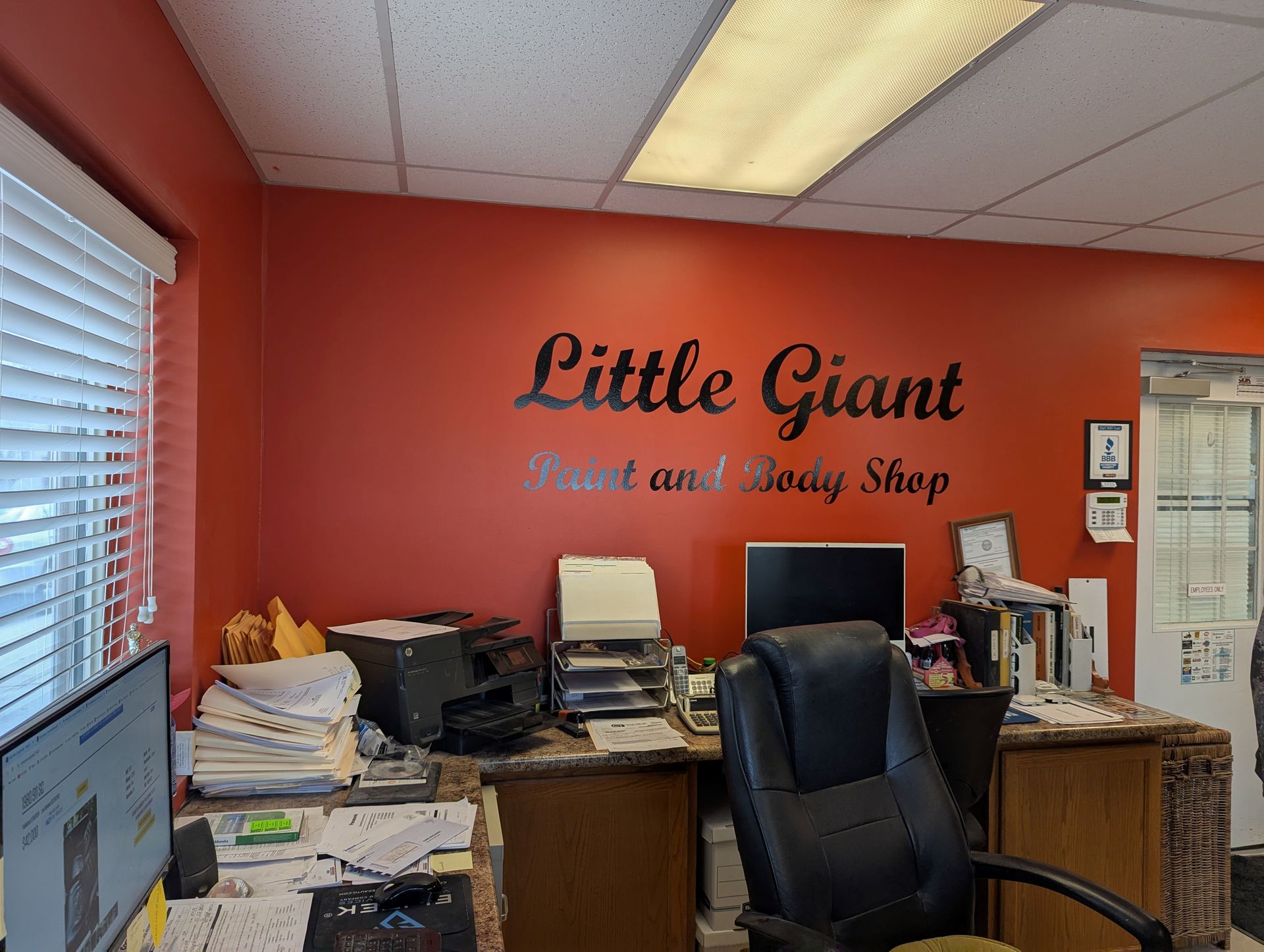 A little giant paint and body shop office with a red wall