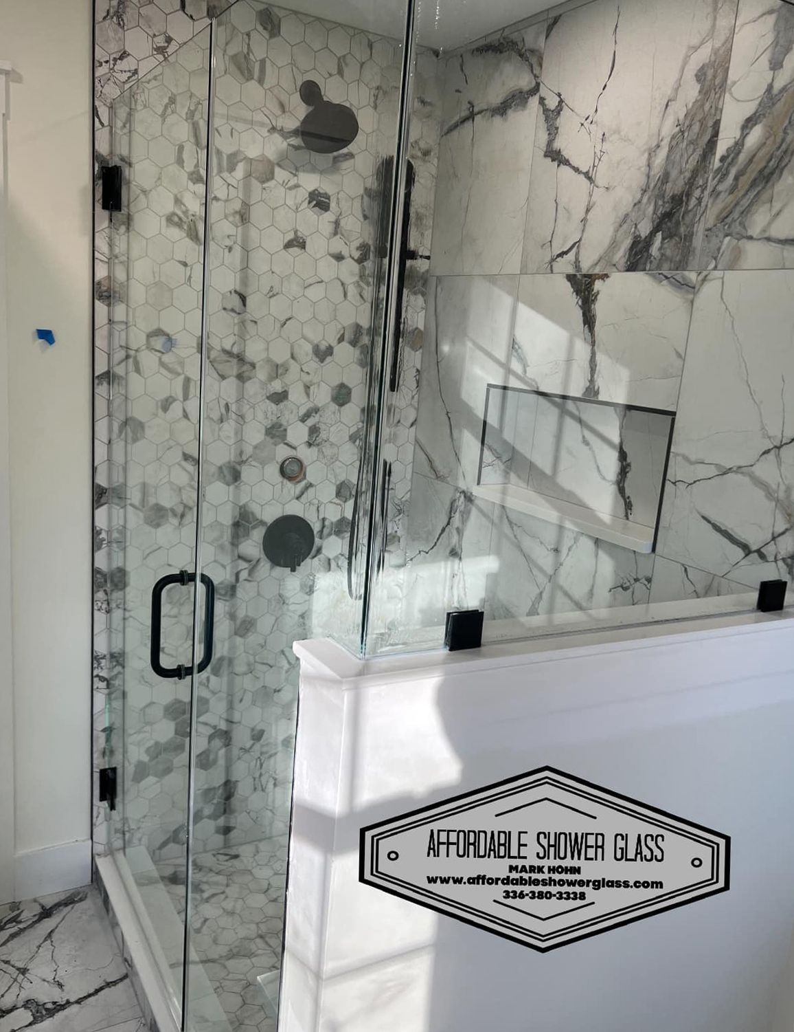 A bathroom with a shower stall and a sign that says affordable shower glass.