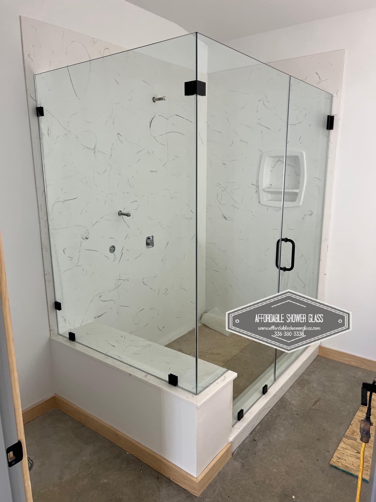 A bathroom with a glass shower door and a bathtub.