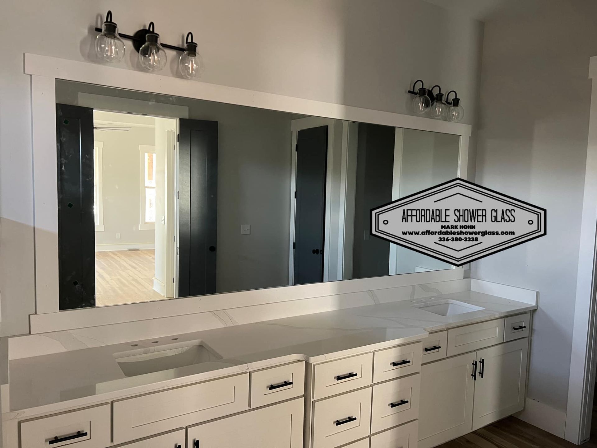 A bathroom with a large mirror and a sink.