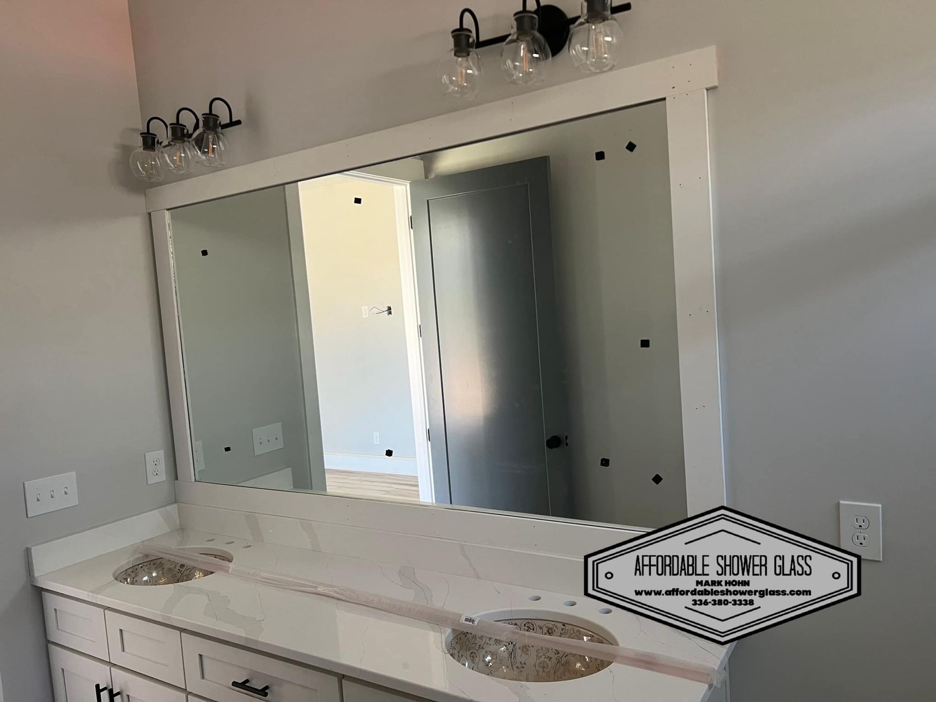 A bathroom with two sinks and a large mirror.