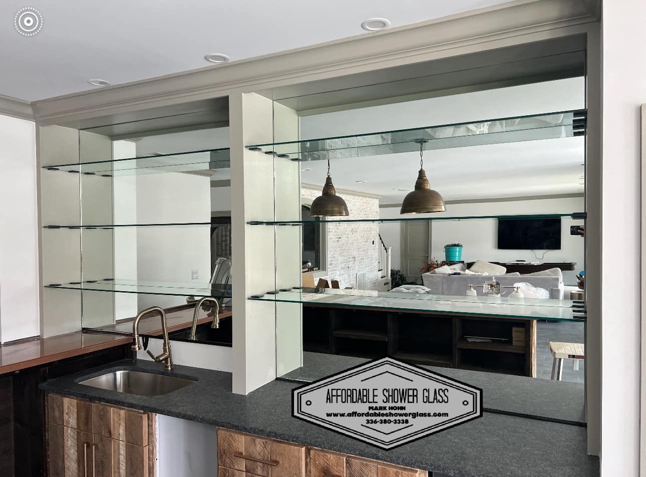 A kitchen with a sink, mirrors and shelves