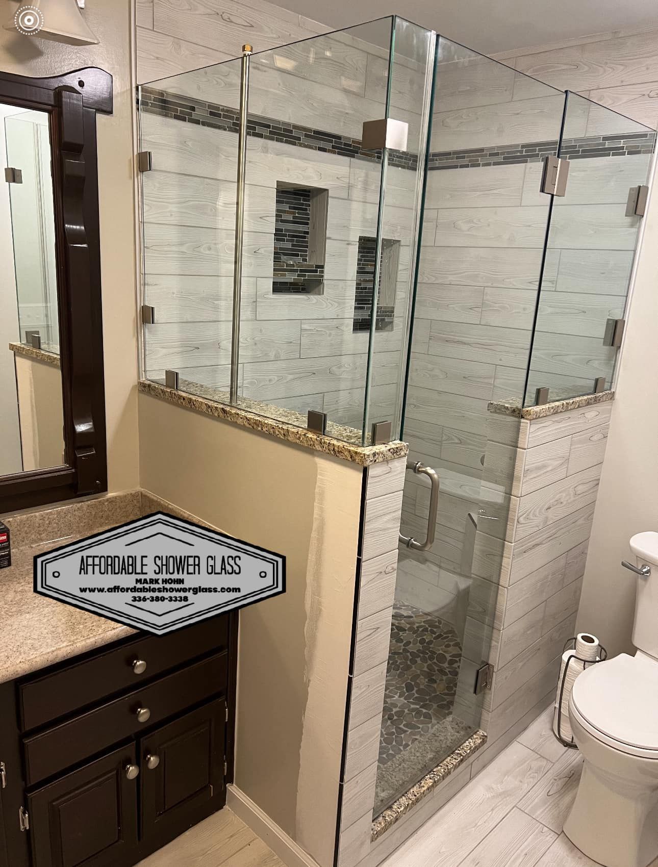 A bathroom with a walk in shower, toilet, sink and mirror.