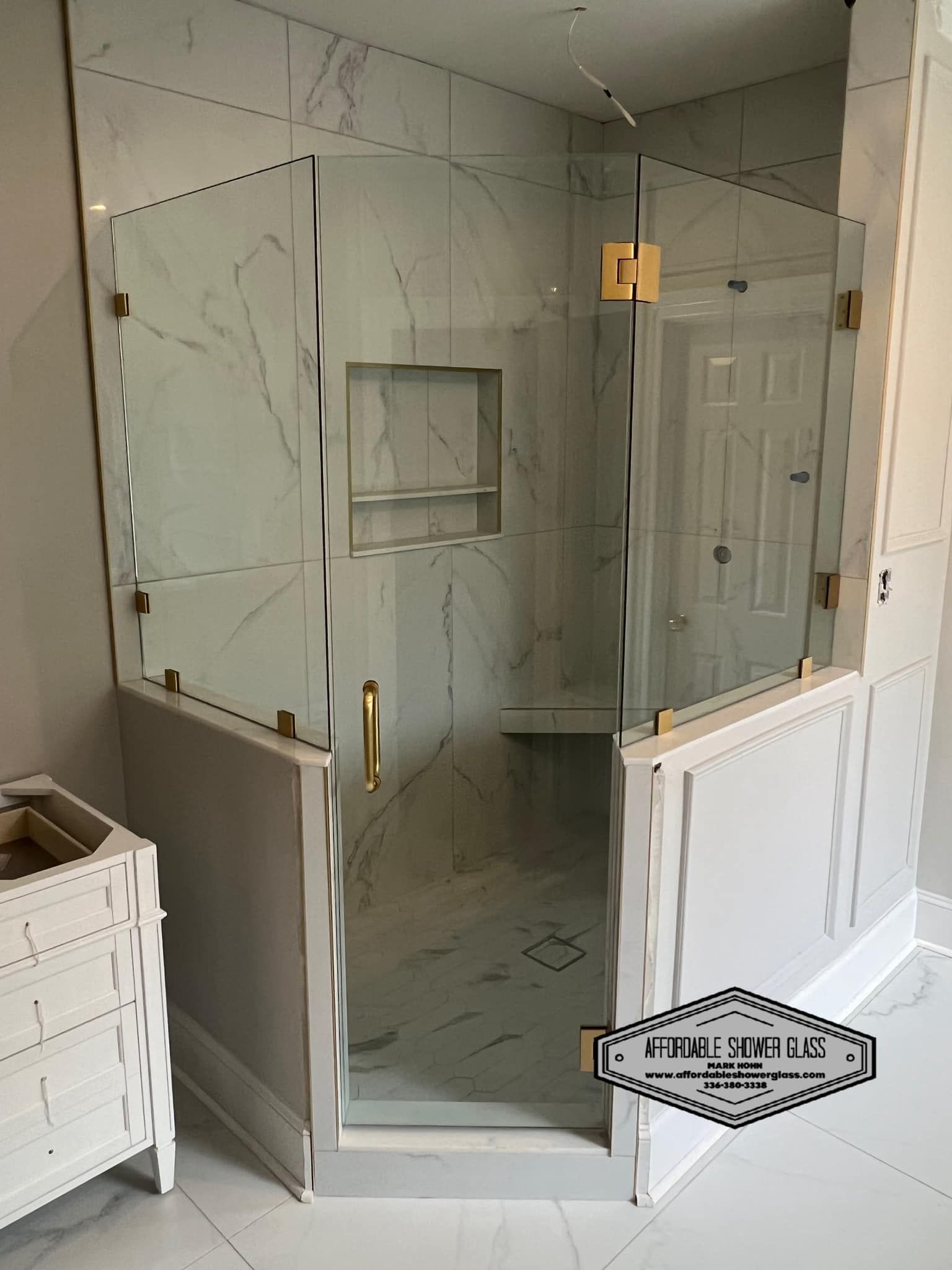 A bathroom with a walk in shower with a glass door.