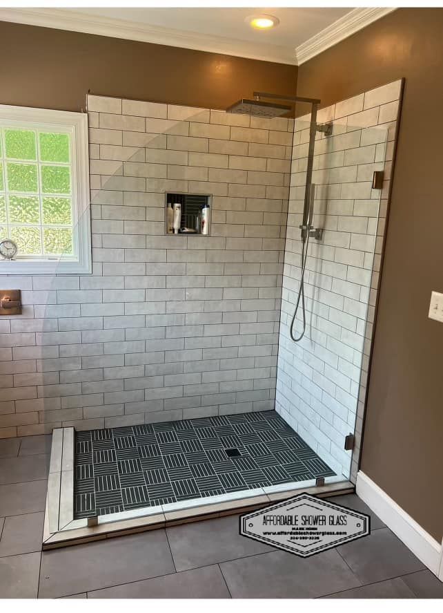A bathroom with a walk in shower and a window.