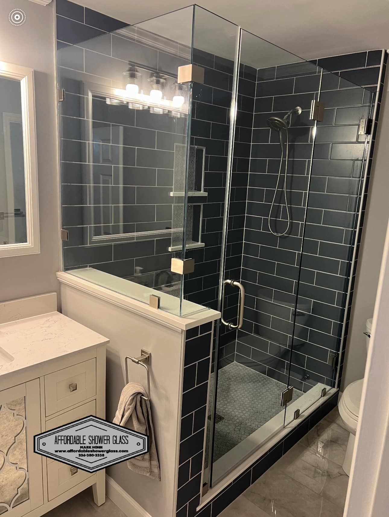 A bathroom with a walk in shower, sink, mirror and toilet.