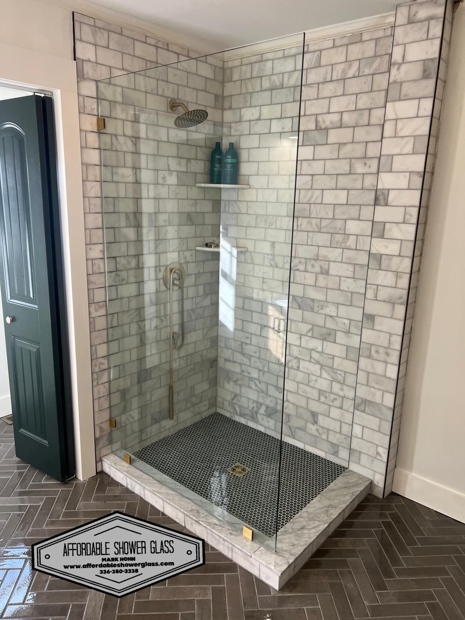 A bathroom with a walk in shower and a brick wall.
