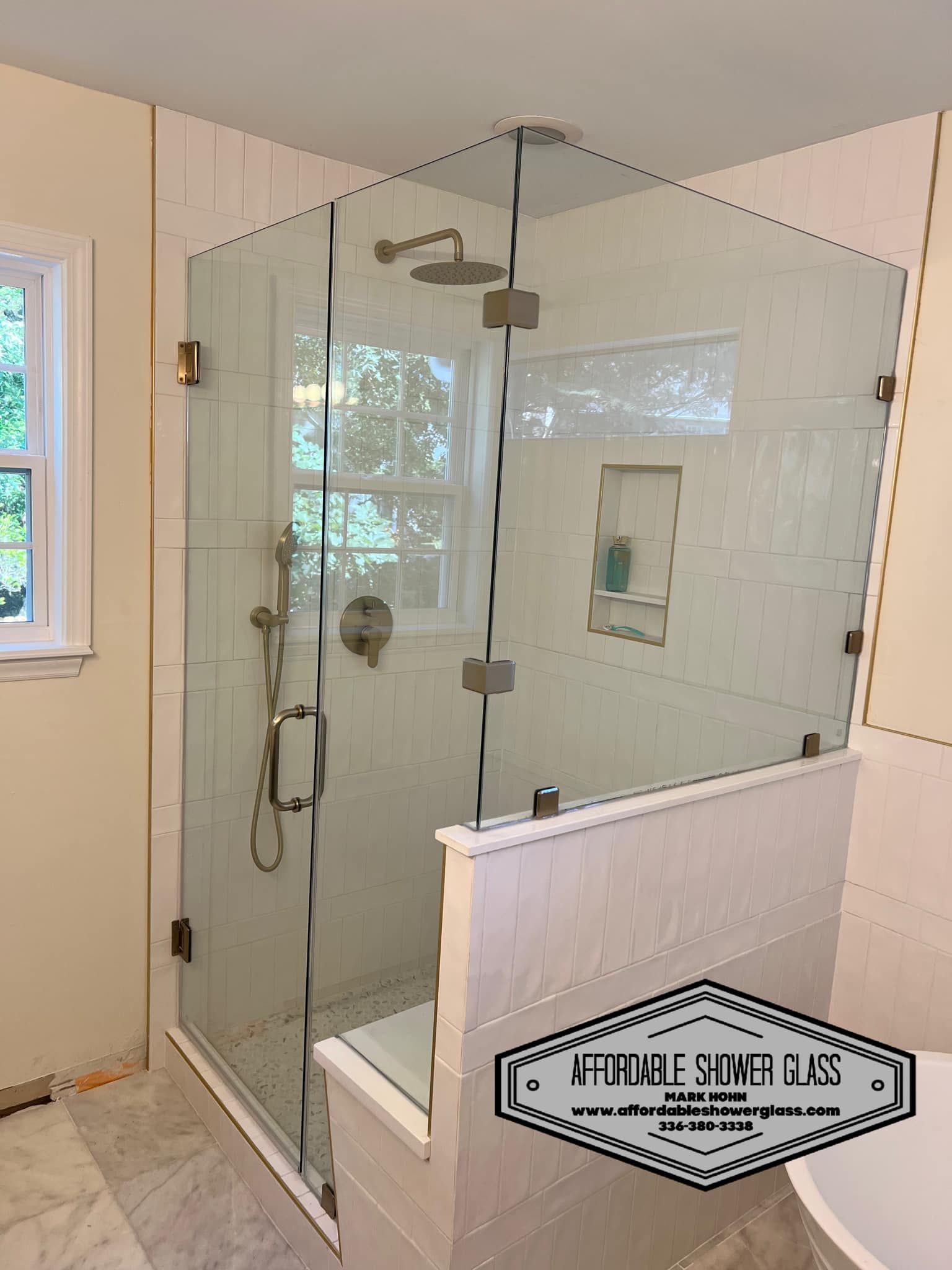 A bathroom with a glass shower door and a window.