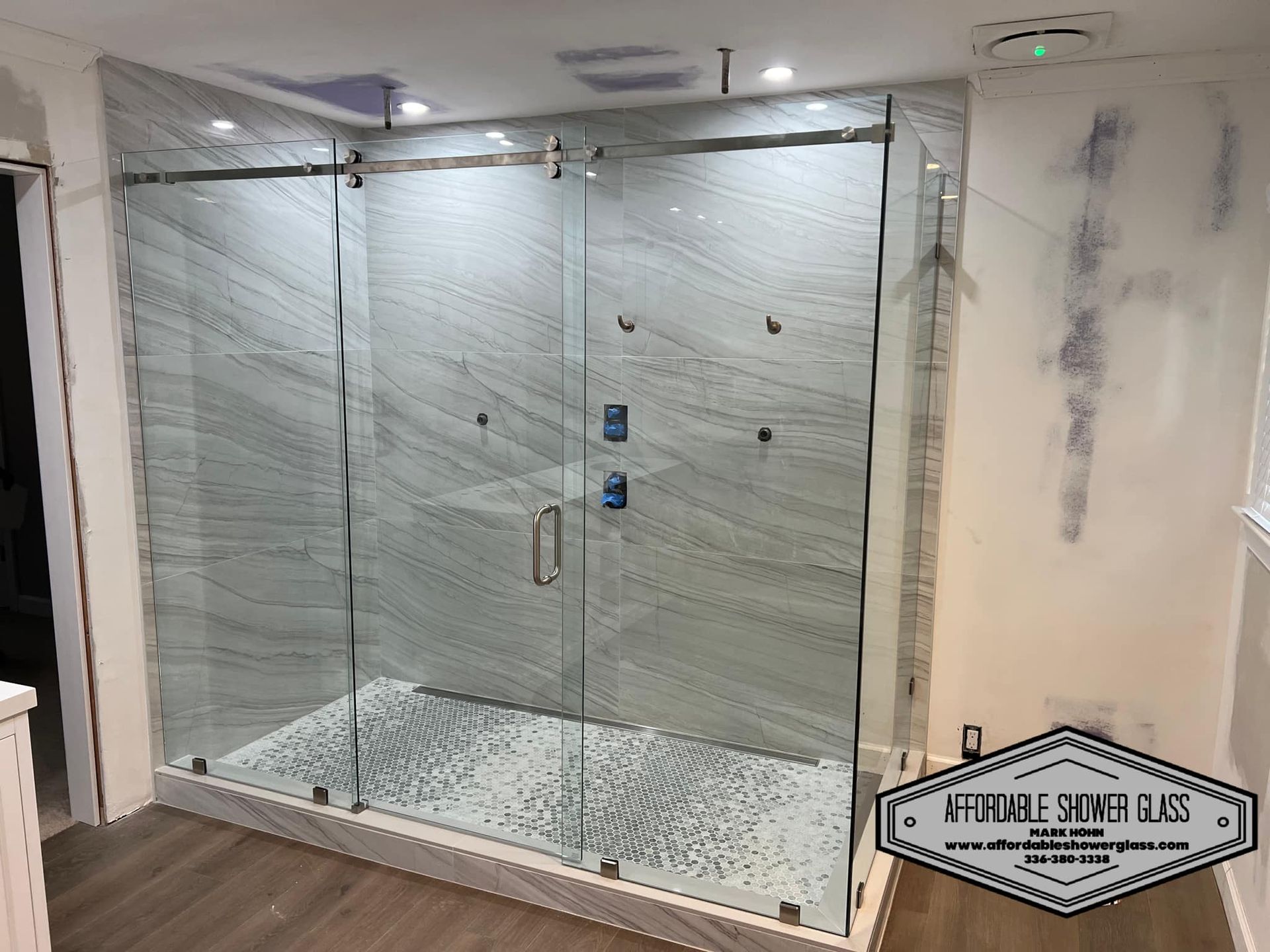 A shower stall with sliding glass doors in a bathroom.