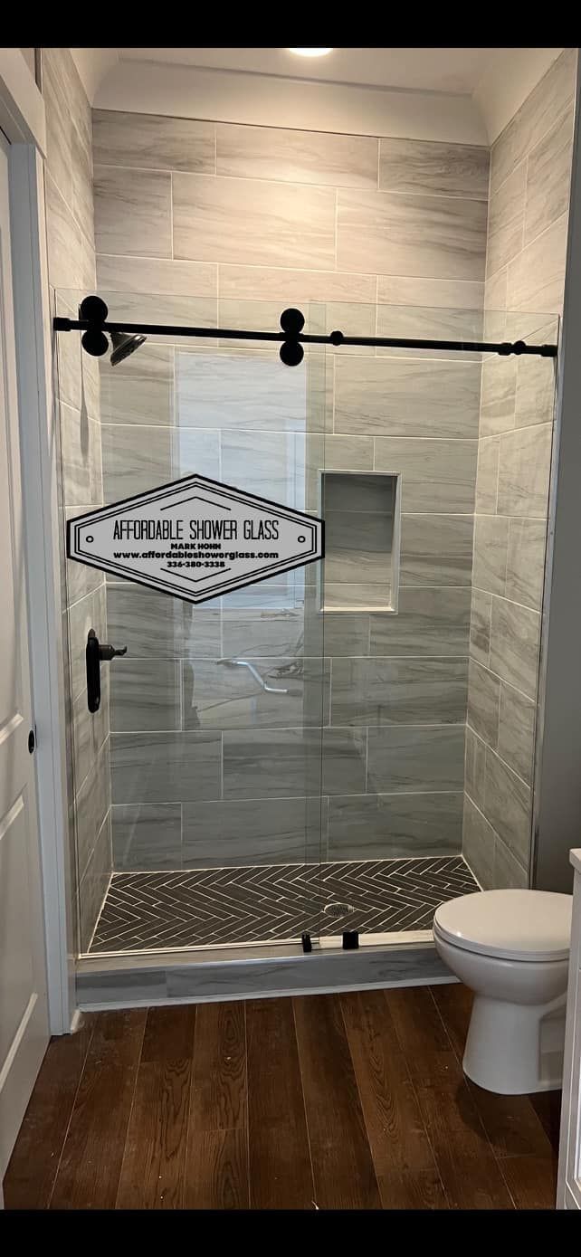 A bathroom with a sliding glass shower door and a toilet.