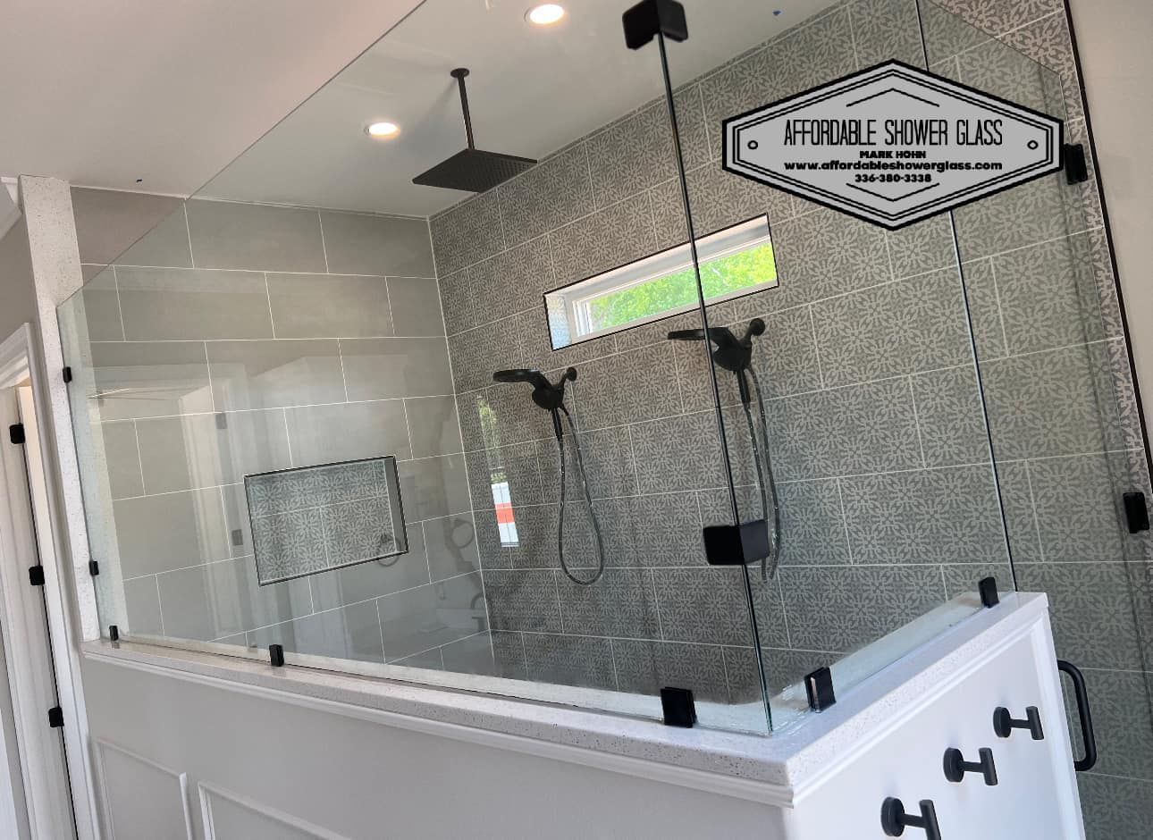 A bathroom with a walk in shower with a glass door.