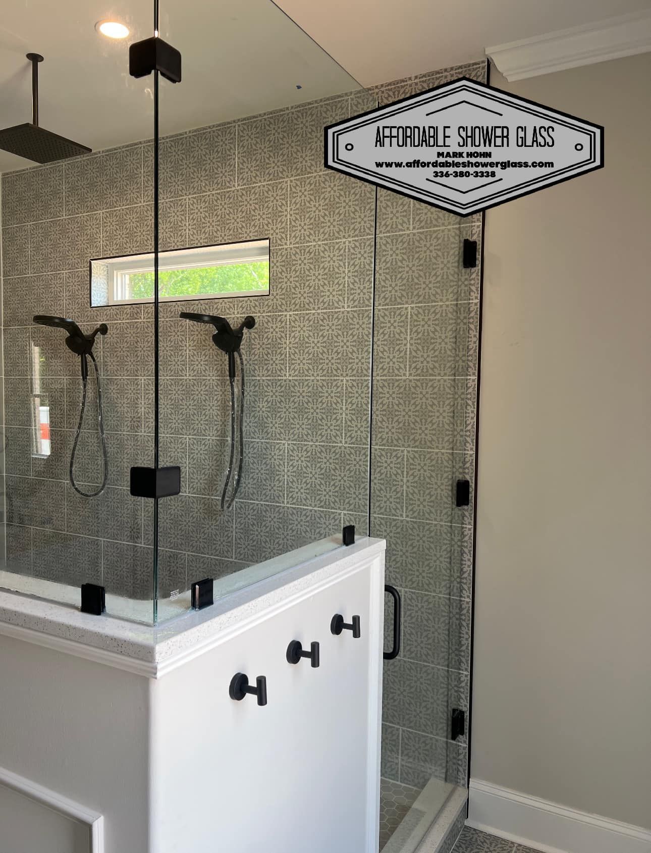 A bathroom with a walk in shower with a glass door.