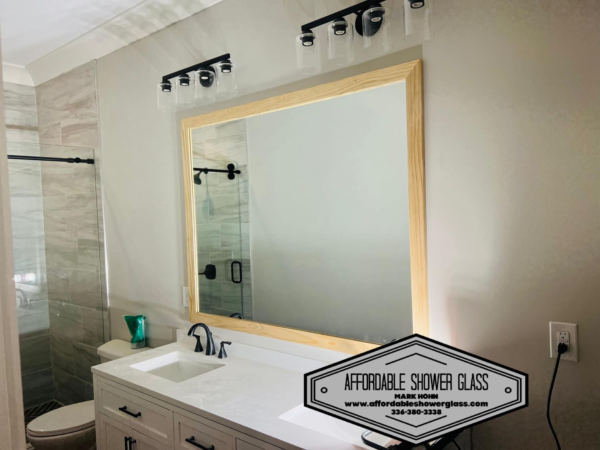 A bathroom with a sink, toilet, and mirror.