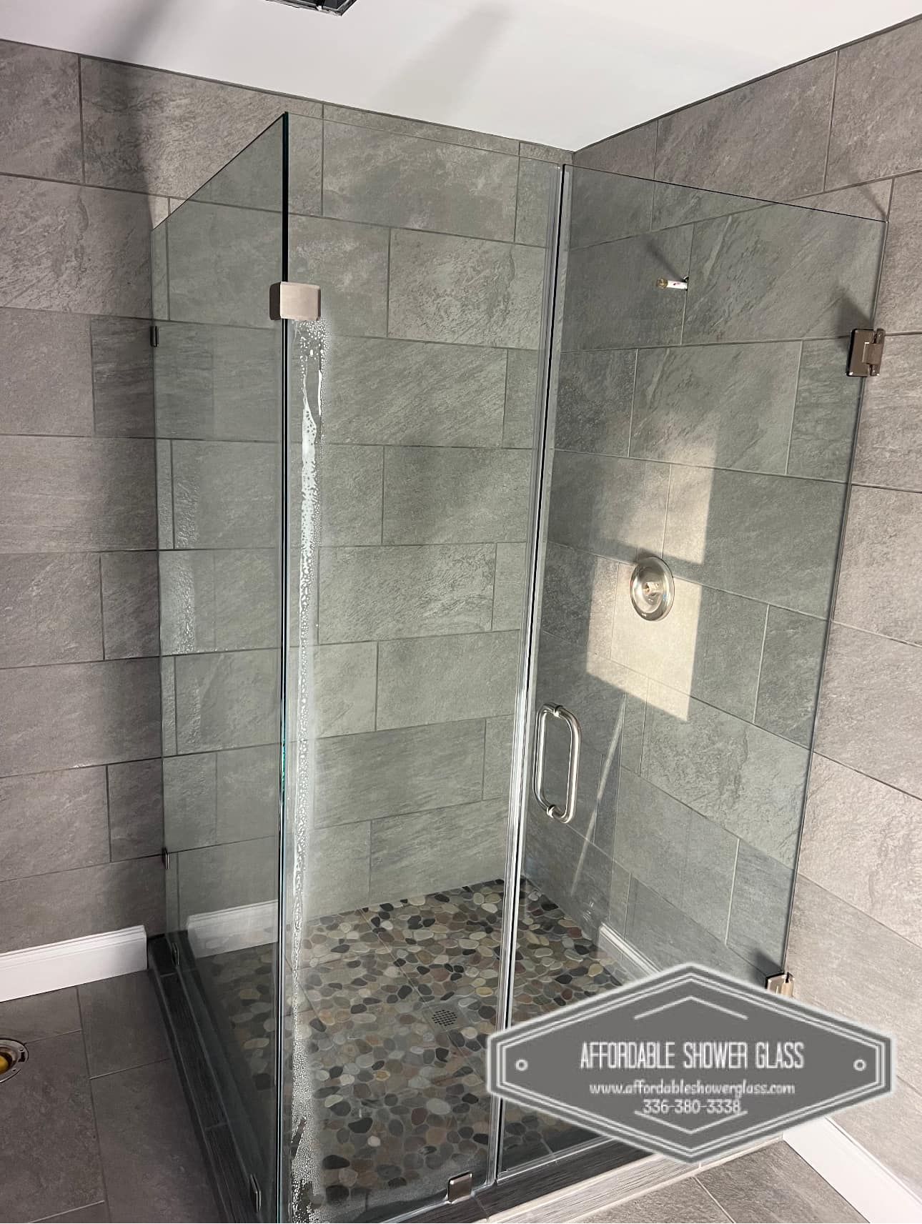 A bathroom with a walk in shower with a glass door.