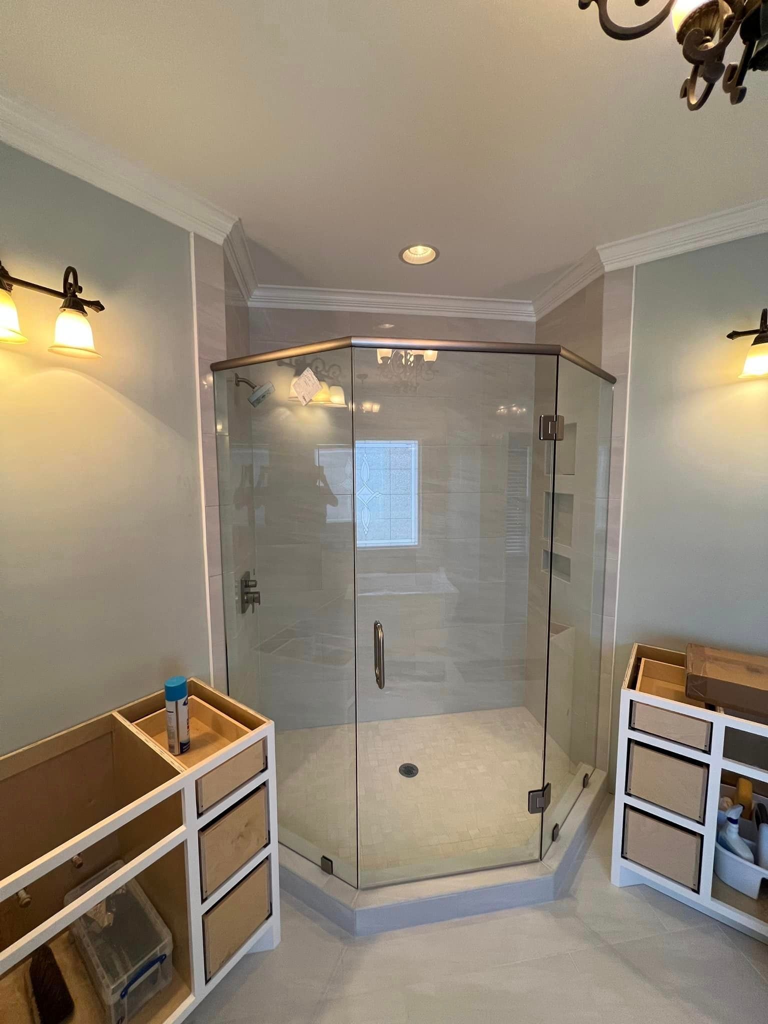 A bathroom with a walk in shower and two mirrors.