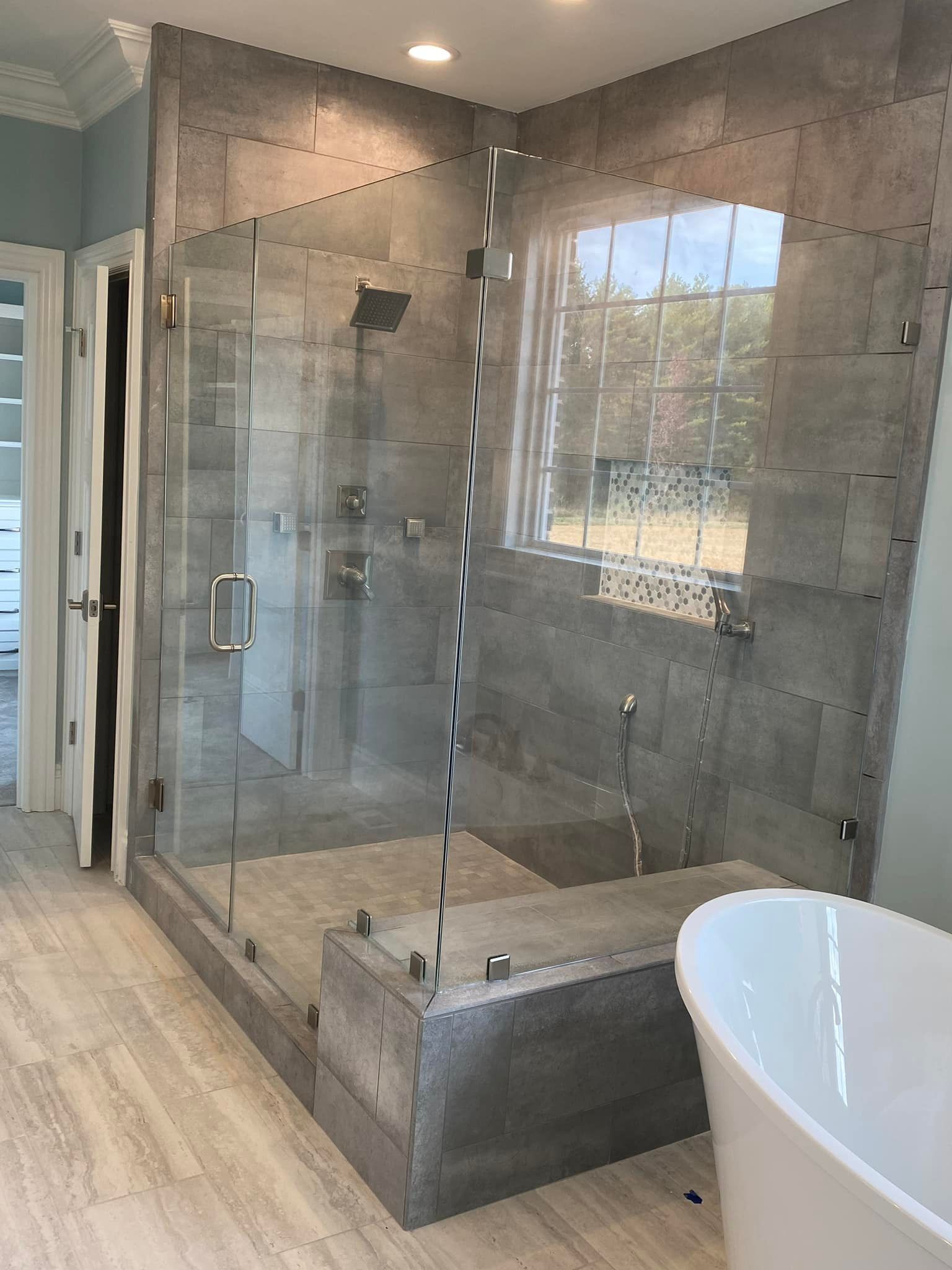 A bathroom with a walk in shower and a bathtub.